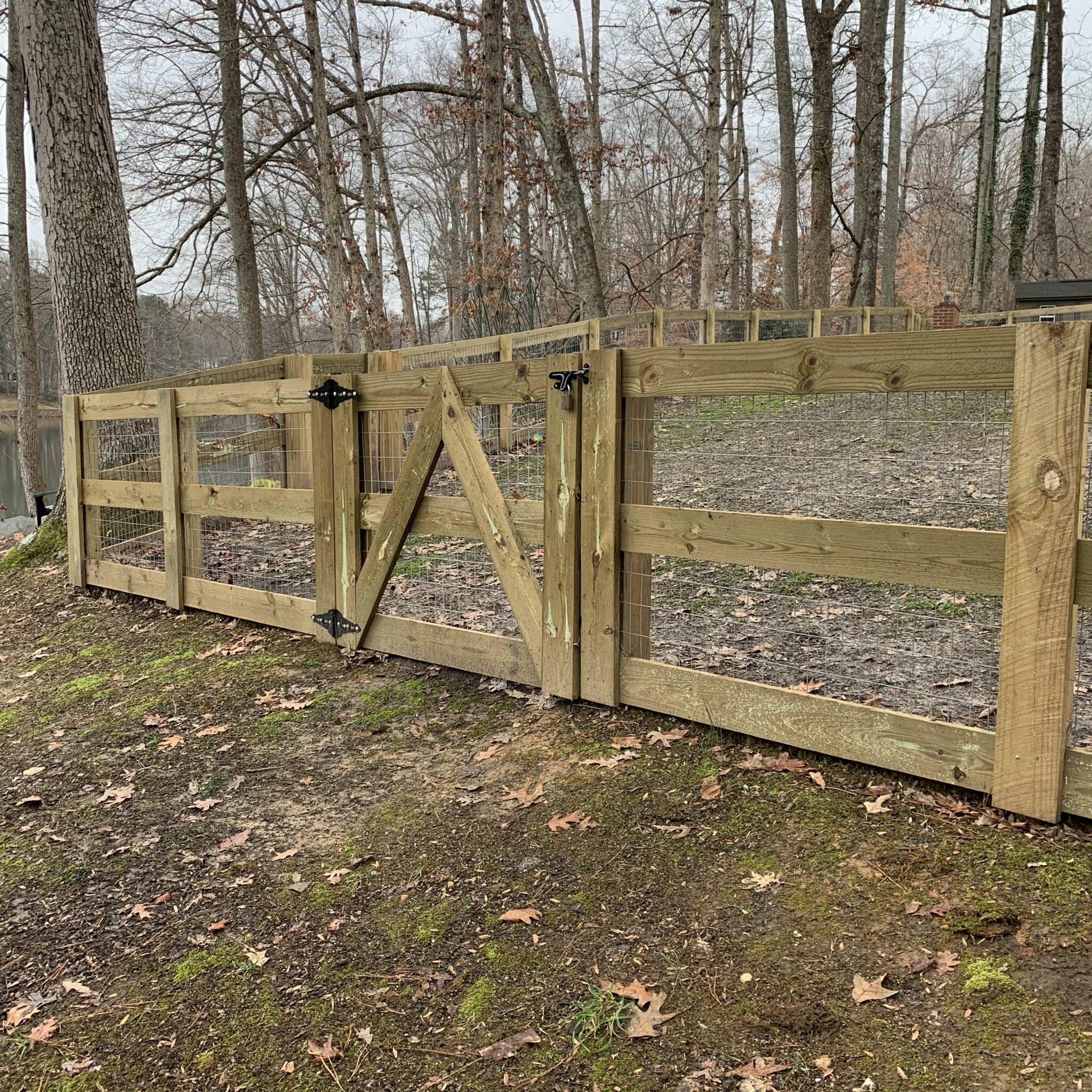 Horizontal board fence secured with welded wire and a locking gate.