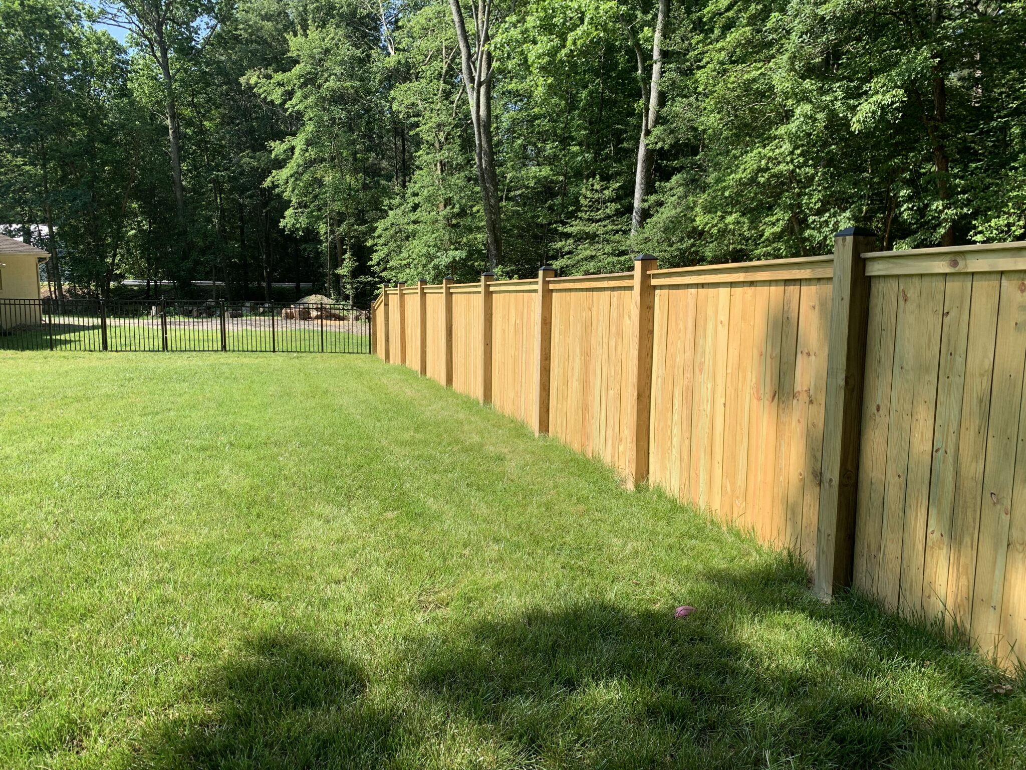 Top cap and finish board wood privacy fence tied to aluminum fencing