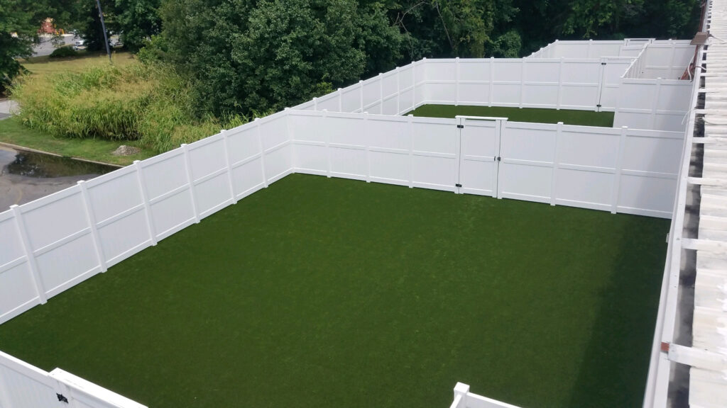 Eight foot tall white vinyl tongue-and-groove privacy fencing.