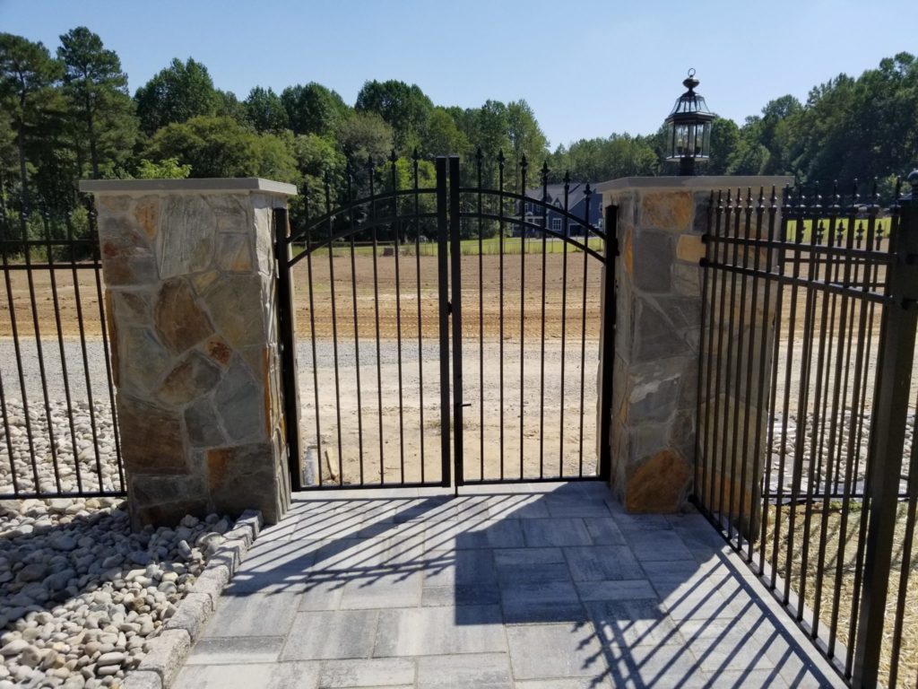 Aluminum gate with finials on stone columns