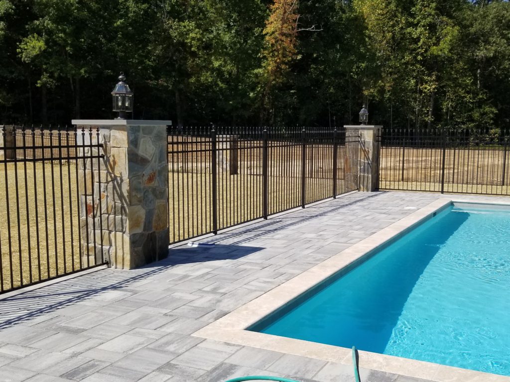 Aluminum fence with finials mounted to stone columns