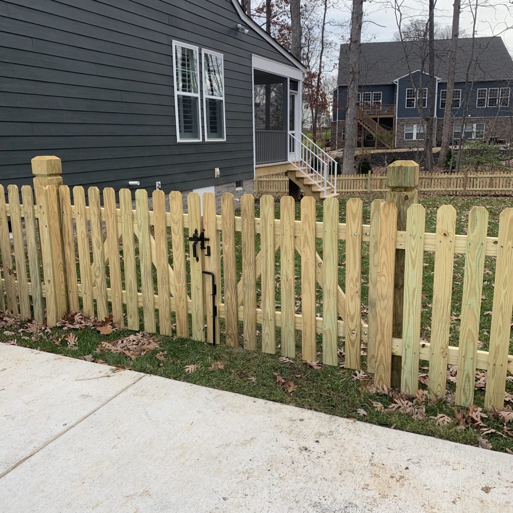Dog ear picket fence on beveled and notched posts.