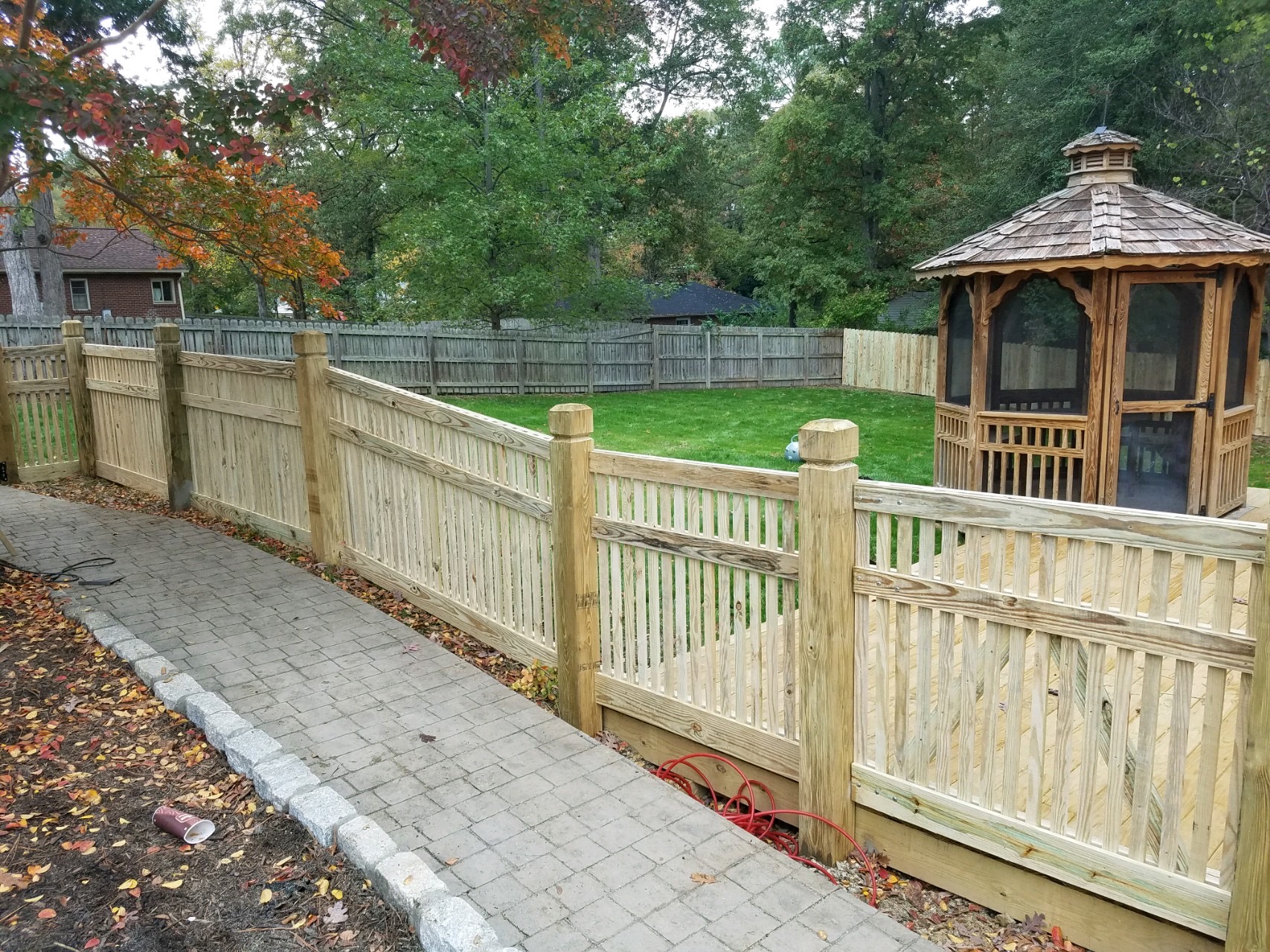 Specialty wood picket fencing with beveled and notched exposed posts