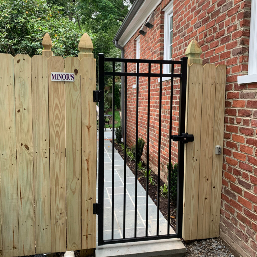 Six foot high wood privacy fence featuring french gothic posts and a series-a 3-rail commercial aluminum gate.